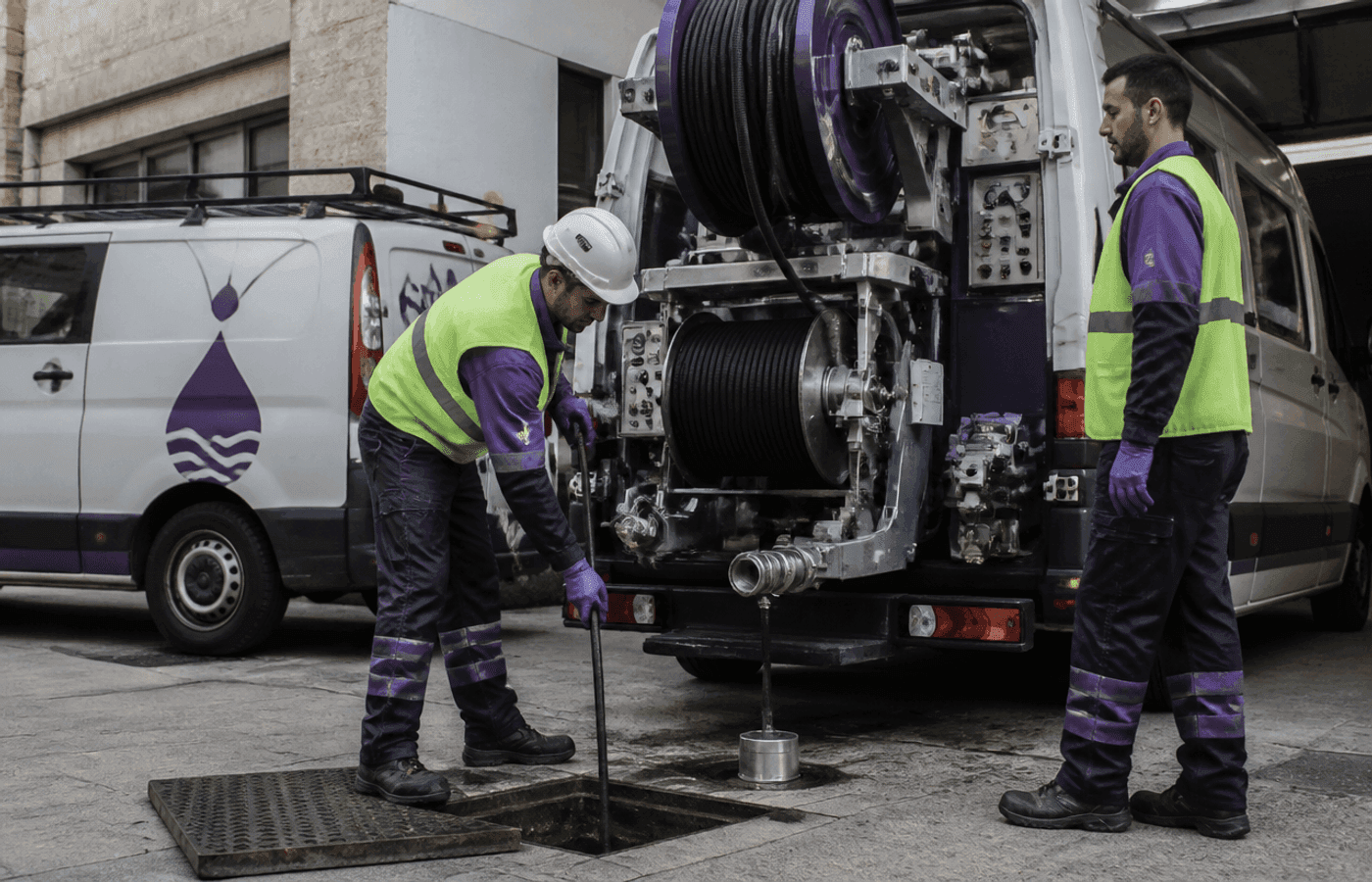 Equipo profesional preparando maquinaria de desatascos junto a la flota de vehículos en Alicante