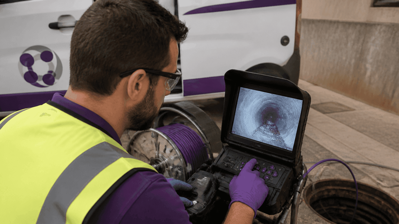 Monitor de obra mostrando el interior de un conducto mientras un técnico supervisa la inspección