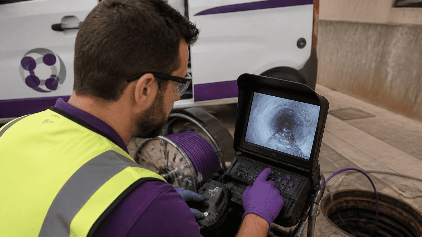 Monitor de obra mostrando el interior de un conducto mientras un técnico supervisa la inspección
